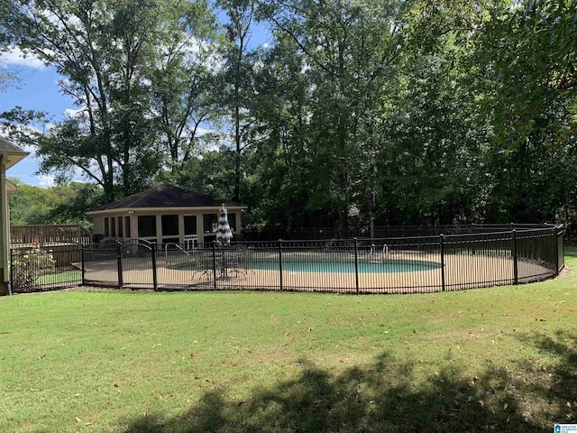 view of swimming pool featuring a yard, fence, and a fenced in pool