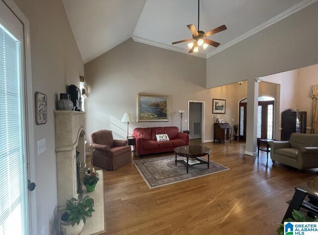 living room featuring ceiling fan, high vaulted ceiling, wood-type flooring, and ornamental molding