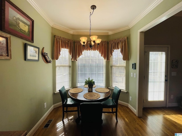 dining area with a chandelier, dark wood-type flooring, visible vents, and crown molding