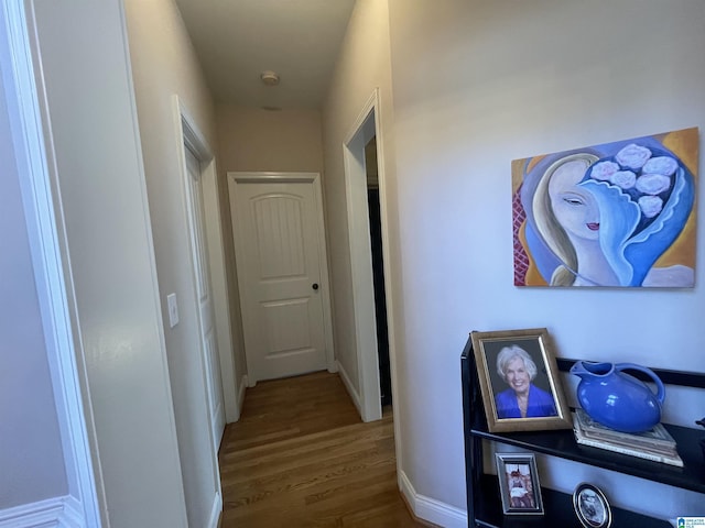 hallway featuring baseboards and wood finished floors