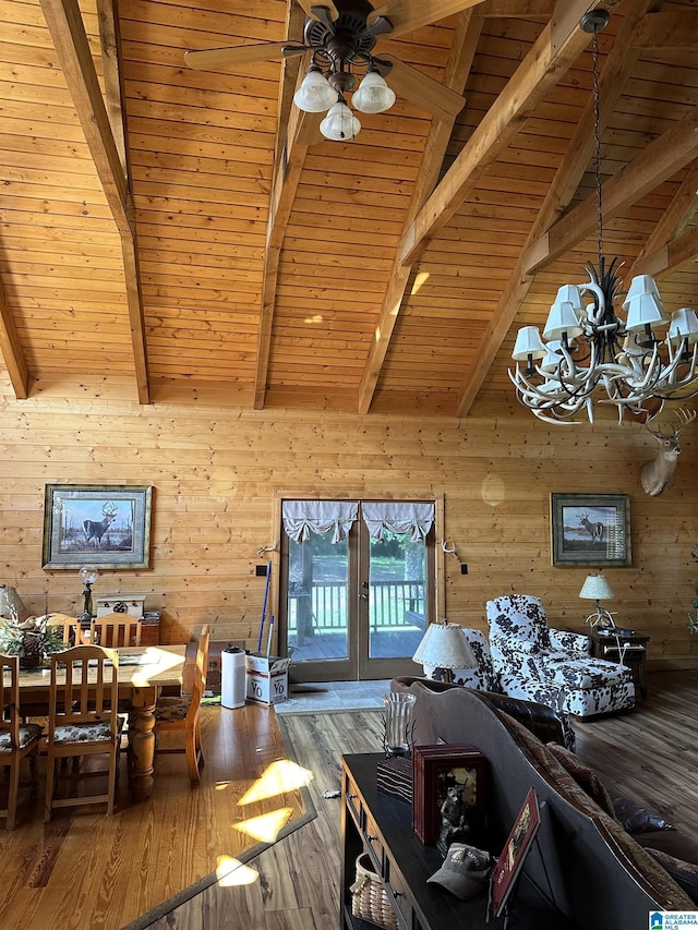 unfurnished living room featuring wooden walls, wood finished floors, wooden ceiling, beamed ceiling, and ceiling fan with notable chandelier