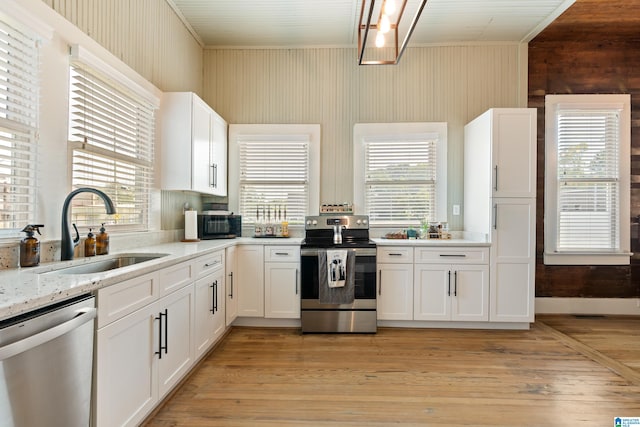 kitchen featuring plenty of natural light, stainless steel appliances, white cabinetry, and light hardwood / wood-style floors