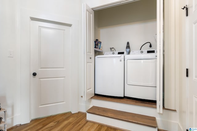 laundry area with light hardwood / wood-style flooring and washing machine and clothes dryer