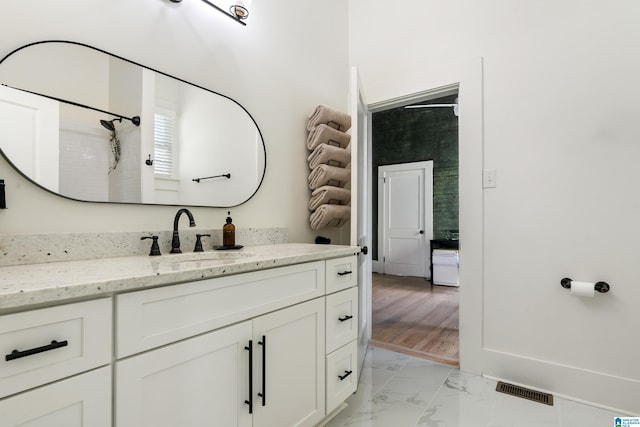 bathroom featuring vanity, wood-type flooring, and walk in shower