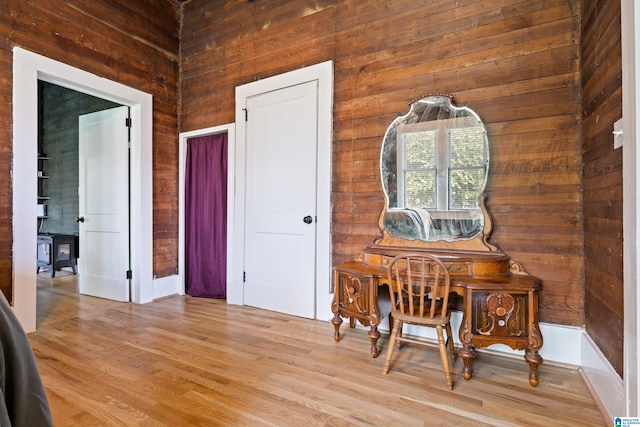 interior space featuring light hardwood / wood-style flooring and wood walls