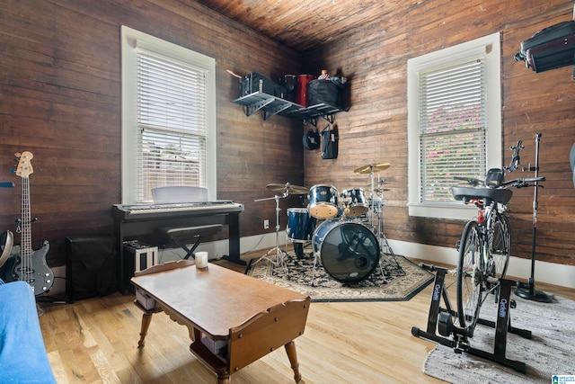 interior space featuring light wood-type flooring, wood ceiling, and wooden walls