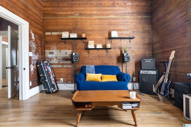 sitting room featuring wooden walls and light hardwood / wood-style floors