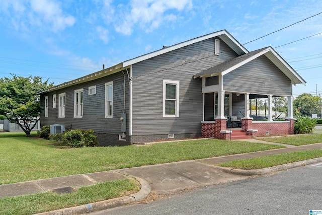 view of front of home featuring cooling unit, covered porch, and a front yard