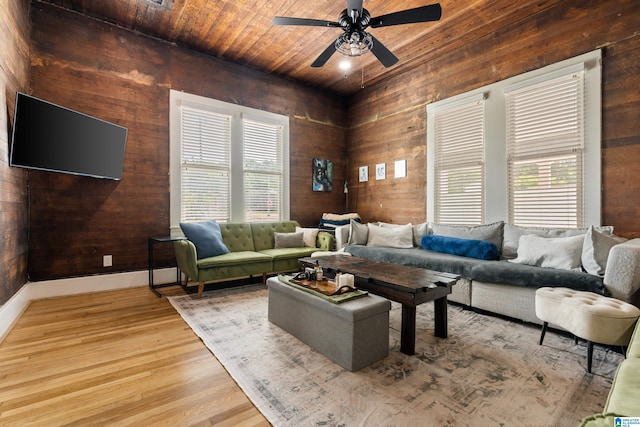 living room featuring light wood-type flooring, ceiling fan, plenty of natural light, and wooden ceiling