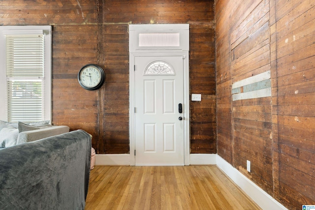 foyer featuring light hardwood / wood-style flooring and wooden walls