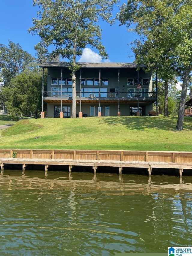 back of property with a yard and a water view