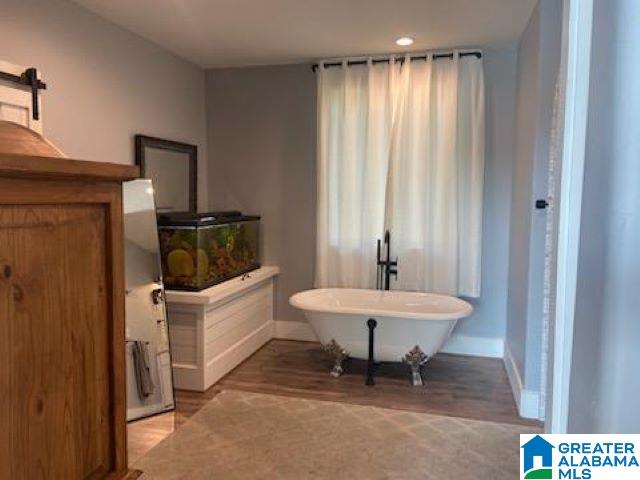 bathroom featuring hardwood / wood-style floors and a washtub