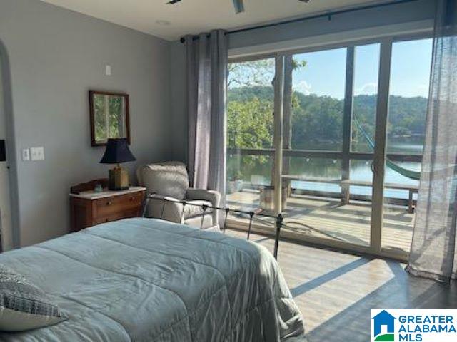 bedroom featuring a water view and wood-type flooring