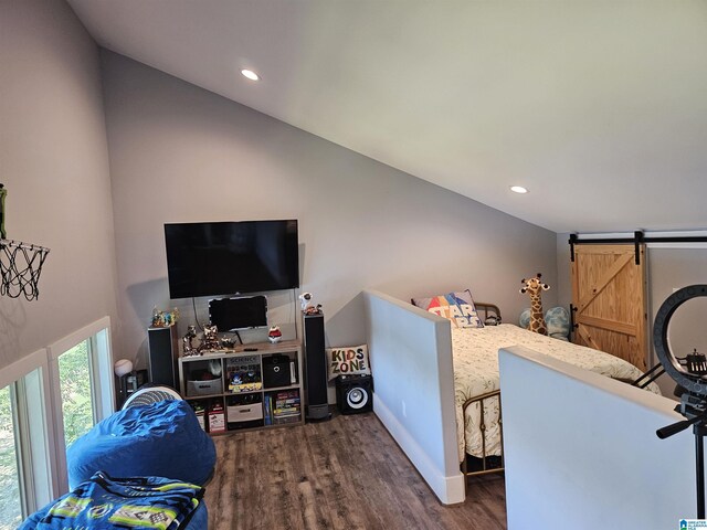 bedroom featuring a barn door and dark hardwood / wood-style floors