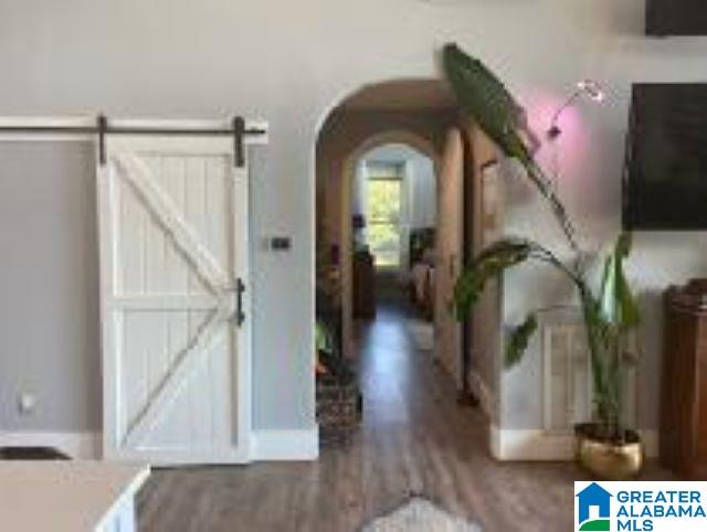 hallway featuring wood-type flooring and a barn door