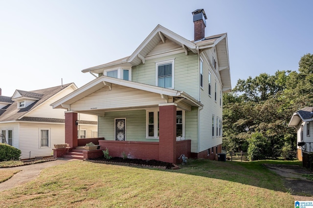 view of front of home featuring covered porch, a front yard, and cooling unit