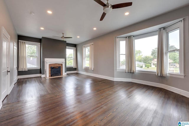 unfurnished living room with plenty of natural light, ceiling fan, and dark hardwood / wood-style floors