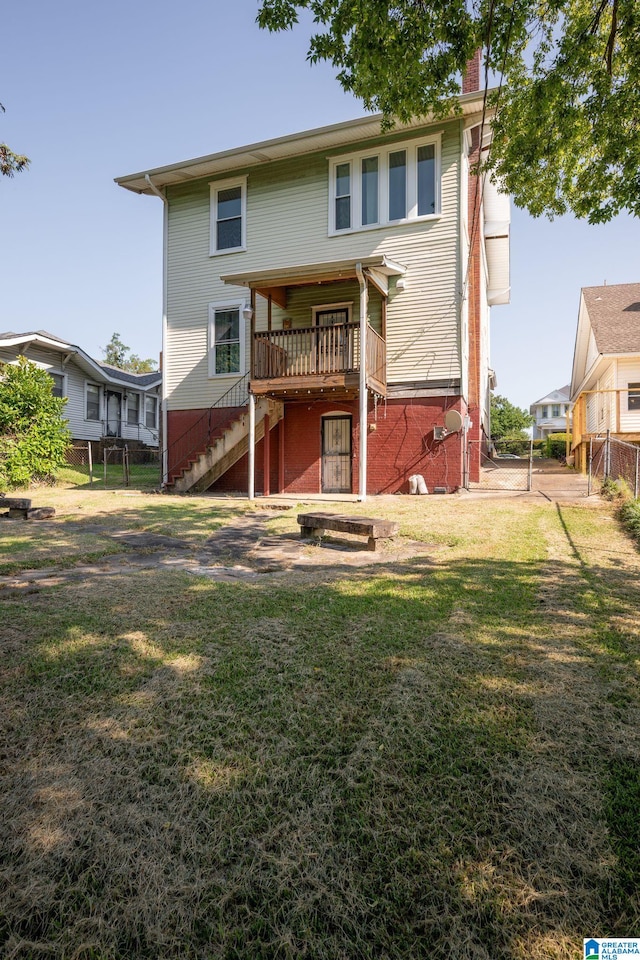 rear view of property with a lawn and a deck