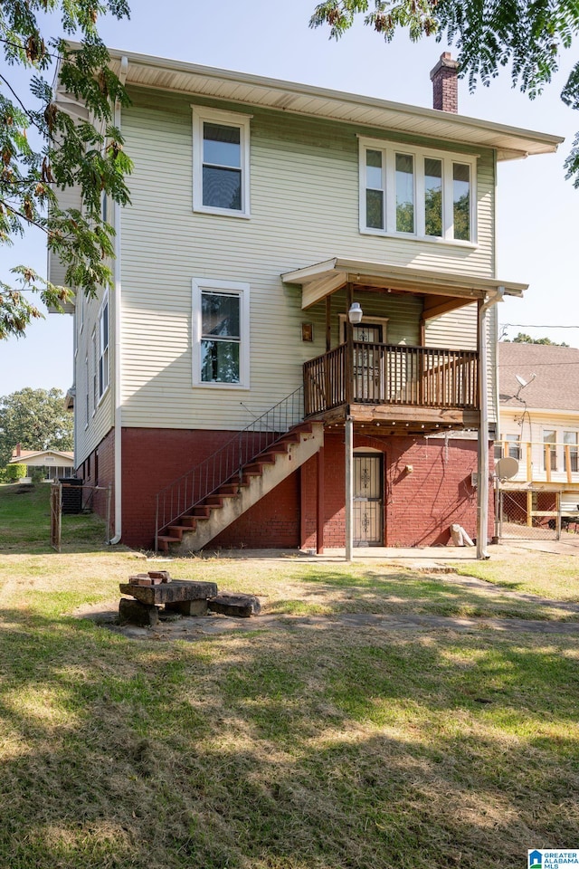 rear view of house featuring a yard and a wooden deck