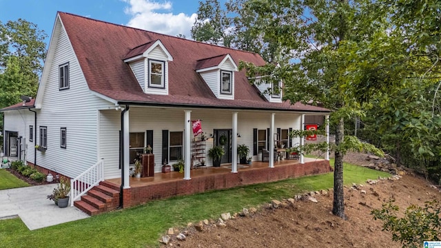 rear view of property featuring covered porch and a yard