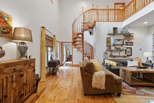 living room with light hardwood / wood-style floors and a high ceiling