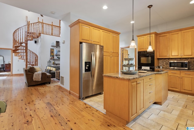 kitchen featuring appliances with stainless steel finishes, decorative backsplash, a kitchen island, light tile patterned flooring, and dark stone countertops