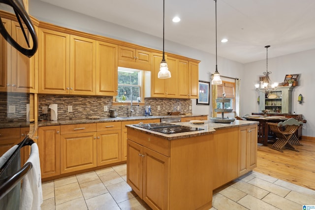 kitchen featuring a kitchen island, black electric cooktop, stone counters, and light wood-type flooring