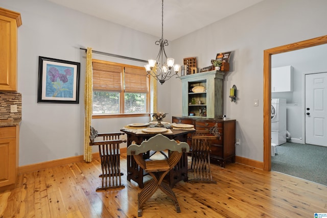 carpeted dining area featuring a notable chandelier and washer / clothes dryer