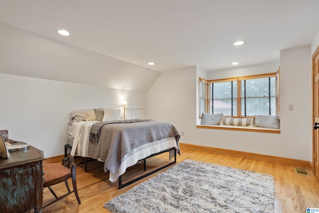 bedroom featuring light wood-type flooring and vaulted ceiling