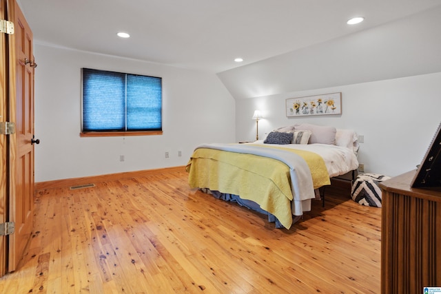 bedroom featuring light hardwood / wood-style floors and lofted ceiling