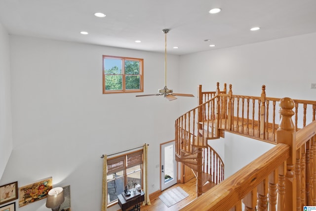 stairs with ceiling fan and wood-type flooring