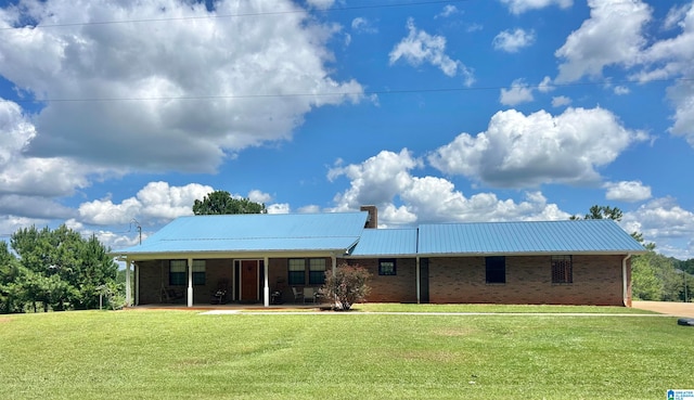 rear view of property featuring a lawn