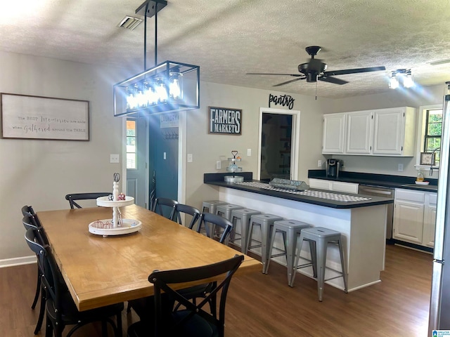 dining room featuring ceiling fan, dark hardwood / wood-style floors, and a textured ceiling