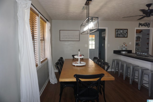 dining area featuring a textured ceiling, ceiling fan, and dark hardwood / wood-style flooring