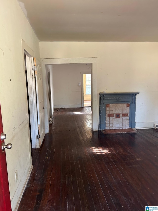 hallway featuring wood-type flooring and baseboards