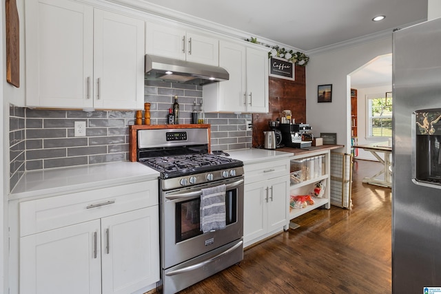 kitchen with dark hardwood / wood-style floors, stainless steel appliances, ornamental molding, decorative backsplash, and white cabinetry