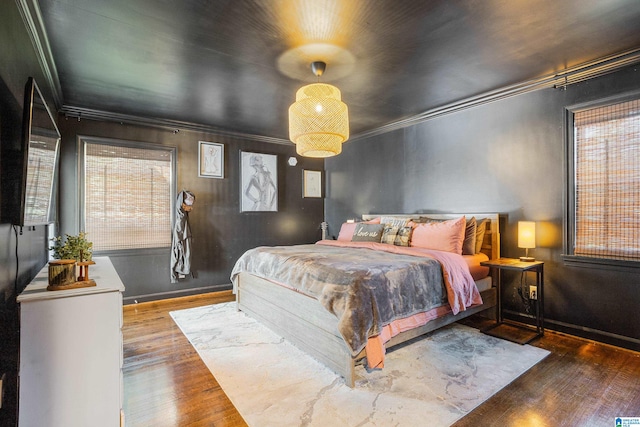 bedroom featuring ornamental molding and hardwood / wood-style floors