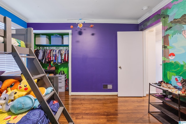 bedroom with crown molding, wood-type flooring, and a closet