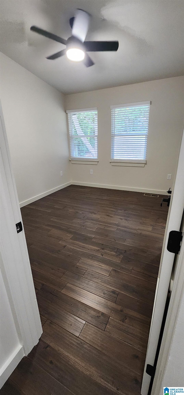 unfurnished room featuring ceiling fan and dark hardwood / wood-style flooring