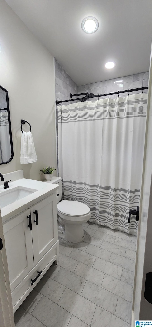 bathroom featuring curtained shower, toilet, and vanity