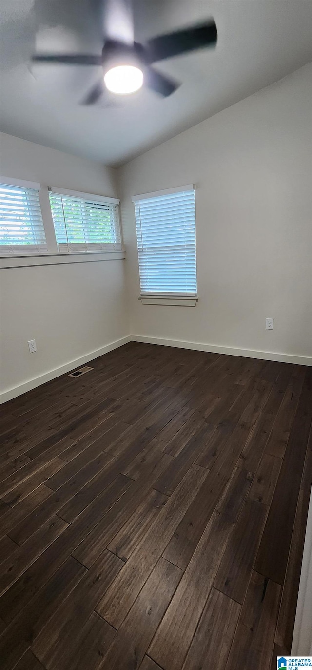 unfurnished room with dark wood-type flooring, ceiling fan, and vaulted ceiling