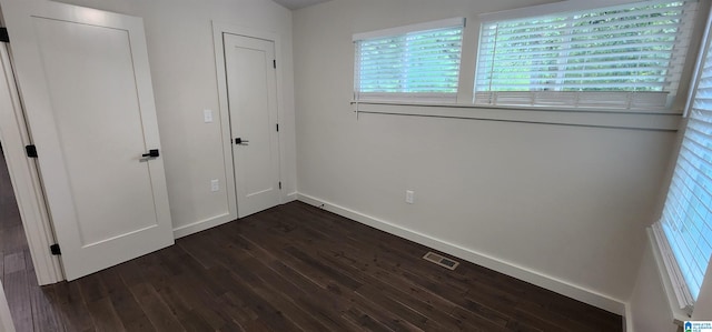 unfurnished bedroom with dark hardwood / wood-style floors