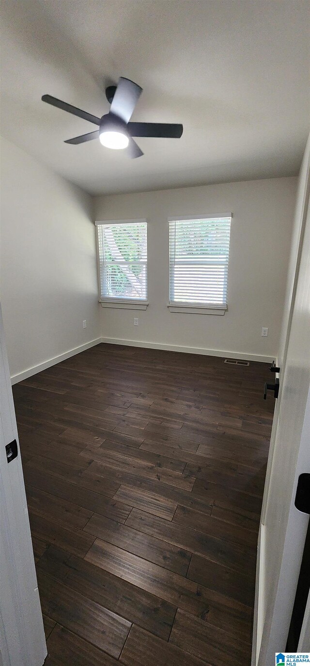 spare room featuring ceiling fan and dark hardwood / wood-style floors