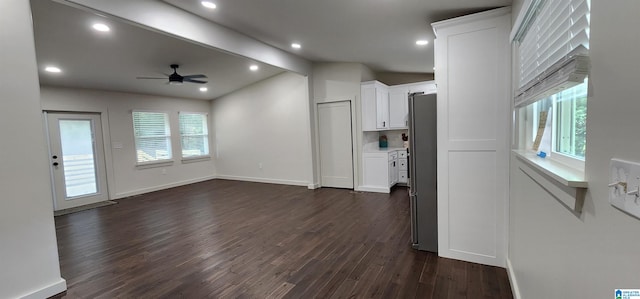 unfurnished living room with ceiling fan, dark hardwood / wood-style floors, beam ceiling, and a healthy amount of sunlight