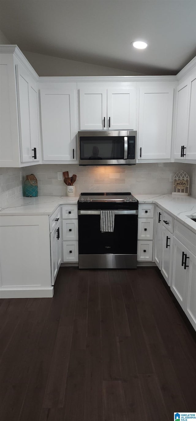 kitchen with vaulted ceiling, appliances with stainless steel finishes, decorative backsplash, light stone counters, and white cabinets