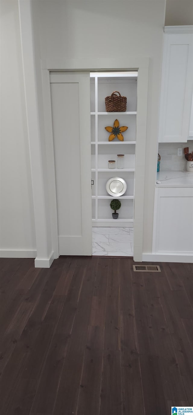 interior details featuring hardwood / wood-style floors and decorative backsplash