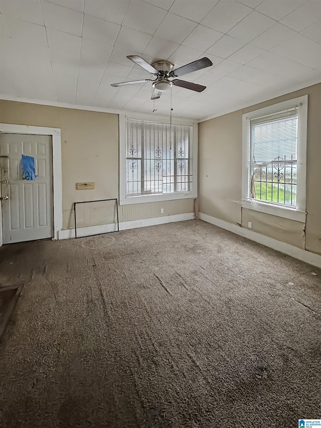 carpeted empty room featuring ceiling fan and crown molding