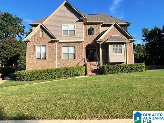 view of front of house featuring brick siding and a front yard