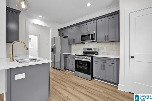 kitchen featuring light hardwood / wood-style floors, appliances with stainless steel finishes, sink, and gray cabinets