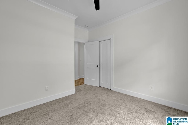 unfurnished bedroom featuring ornamental molding, a closet, light colored carpet, and baseboards